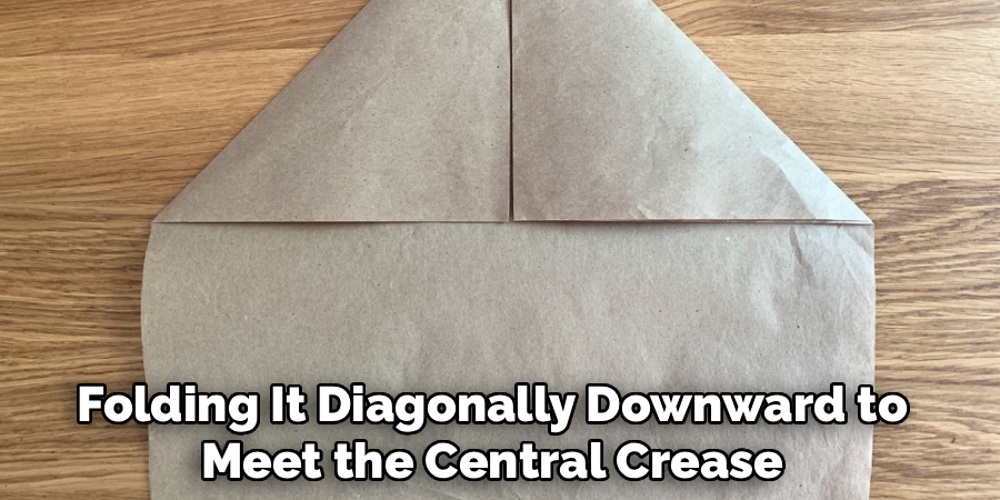 Folding It Diagonally Downward to Meet the Central Crease.